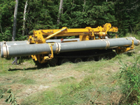 Composite utility poles being transported by lightweight equipment to a wetland location